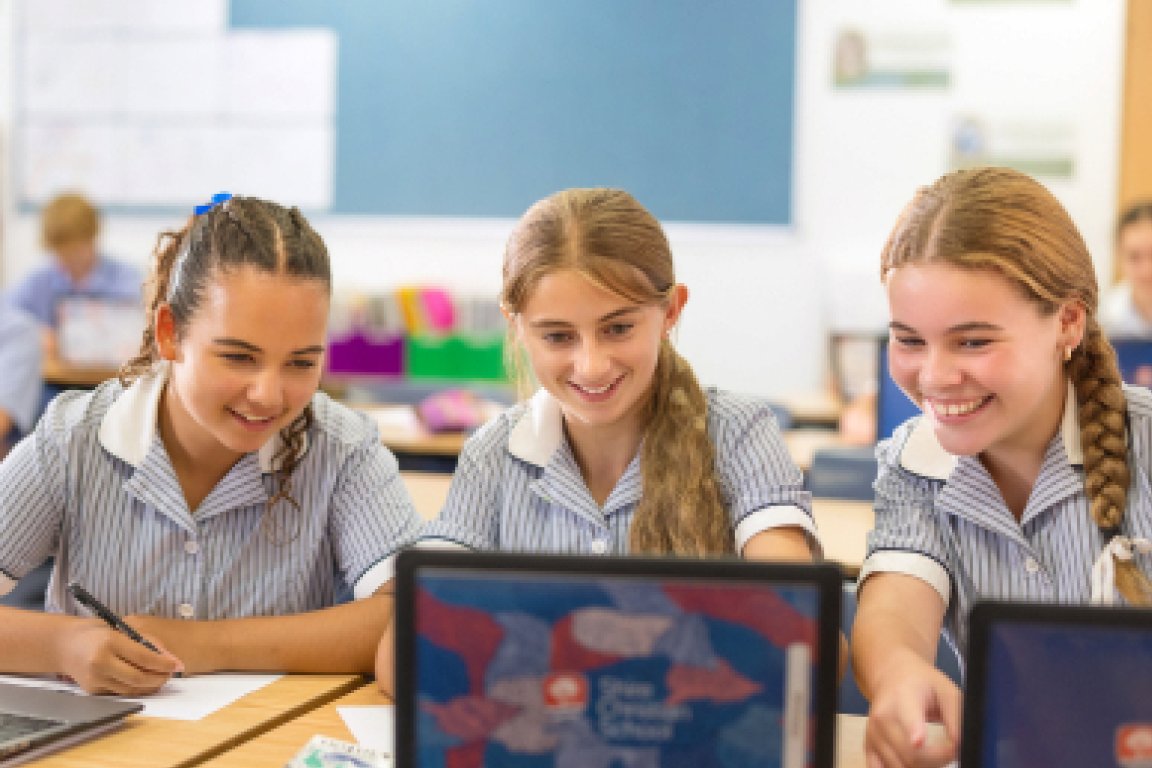 Teacher working with students at desk