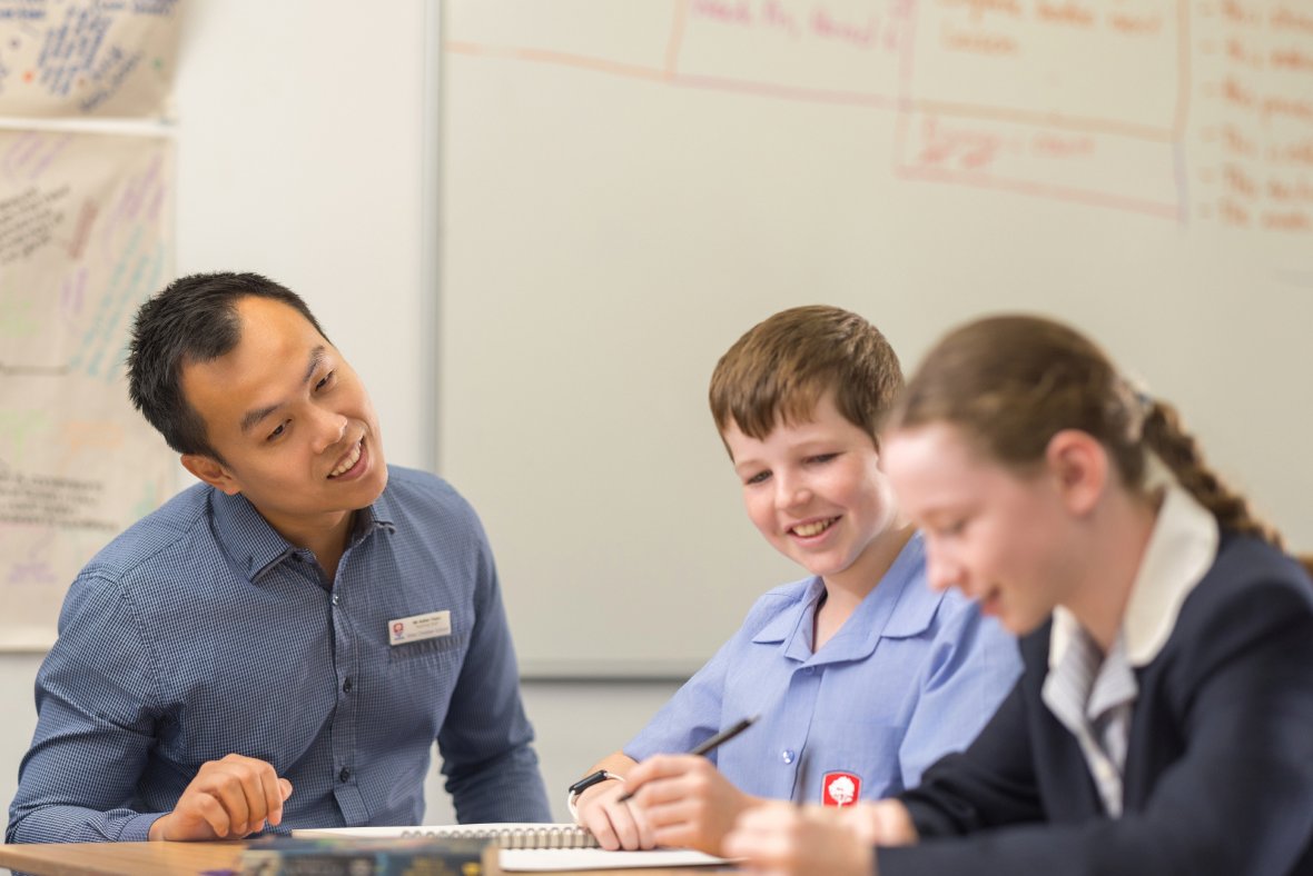 Teacher working with students at desk