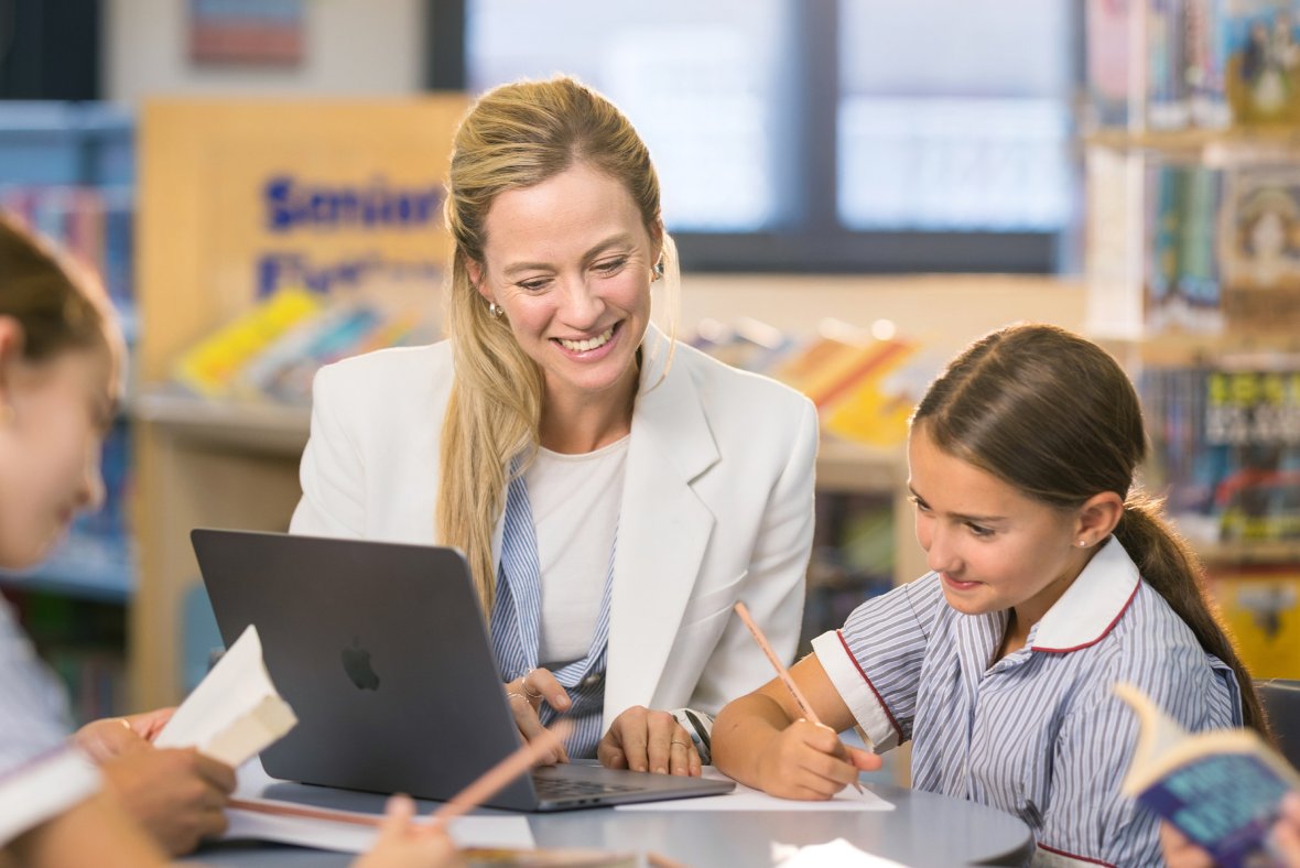 Teacher working with students at desk
